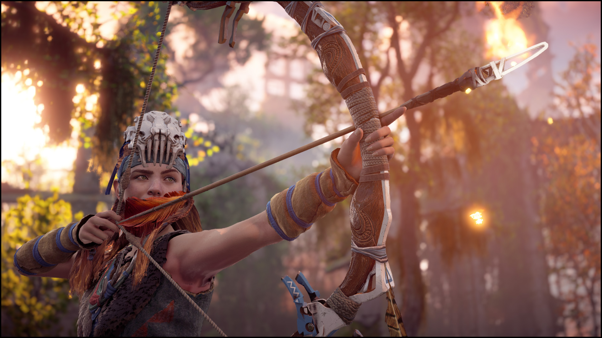 Screenshot of Horizon Zero Dawn. Aloy aims her bow to the right of image, a flame on the arrow tip. She stands under a jungle canopy.