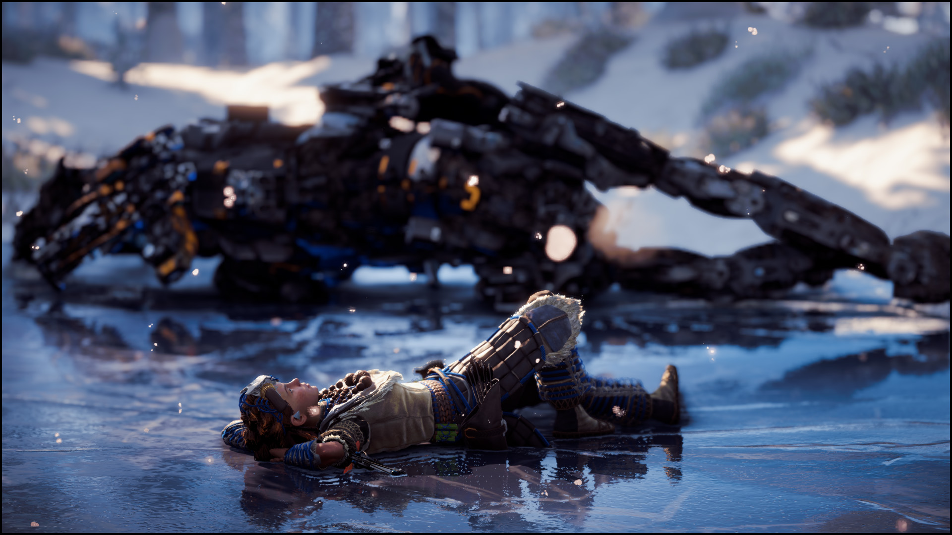 Screenshot of Horizon Zero Dawn. Aloy reclines on her back on the ice, her hands beneath her head. Behind her is a large machine animal she has destroyed.